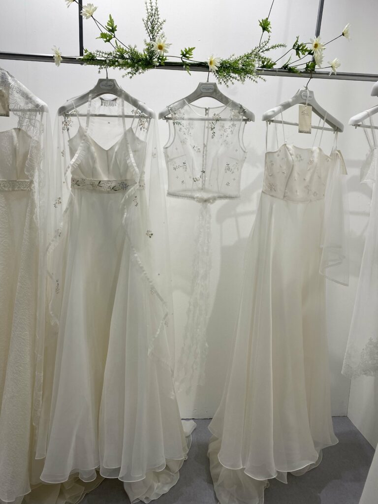 Foto de 2 vestidos de novia blancos de Maison Angela Nobile, con flores bordadas, entre medias un top de seda bordado transparente