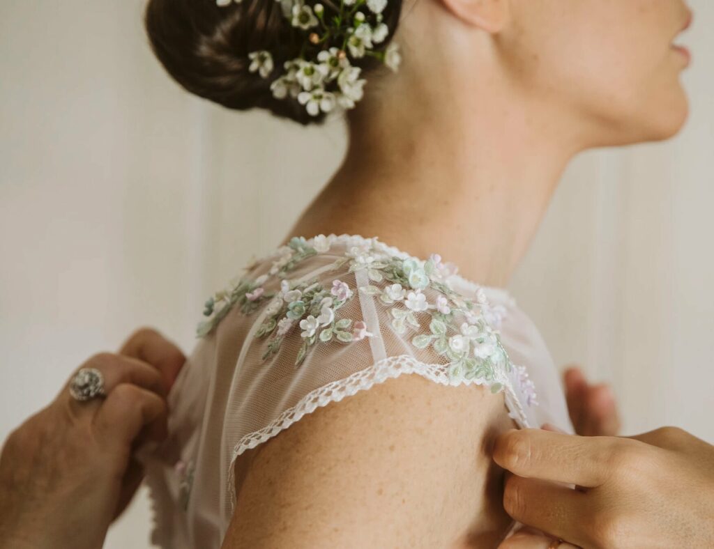 Foto de novia con vestido de encaje y bordado en la manga