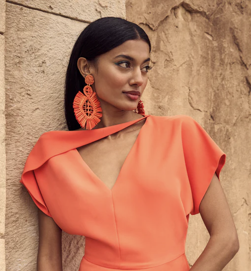 Foto de modelo con vestido y pendientes en color naranja